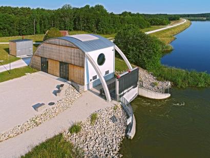 Die außergewöhnliche Architektur der teilweise holzverkleideten Wasserkraftanlage bildet einen markanten Akzent in der Seenlandschaft.